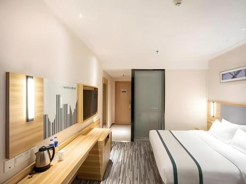 a hotel room with a bed and a tv at City Comfort Inn Hengyang Dayang Department Lianhu Plaza in Hengyang