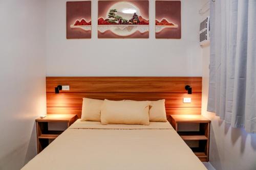 a bedroom with a bed and two paintings on the wall at Urban Chic Home Urban Chic Home with balcony in Pajo