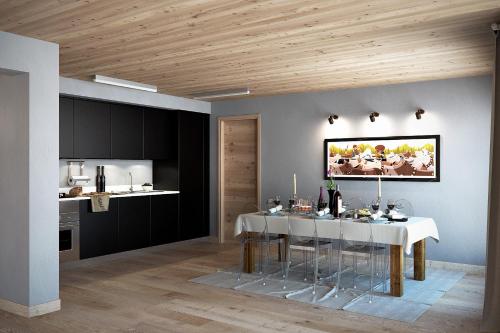 a dining room with a white table and a kitchen at Aux Pieds du Roi - Suite & Spa in Breuil-Cervinia