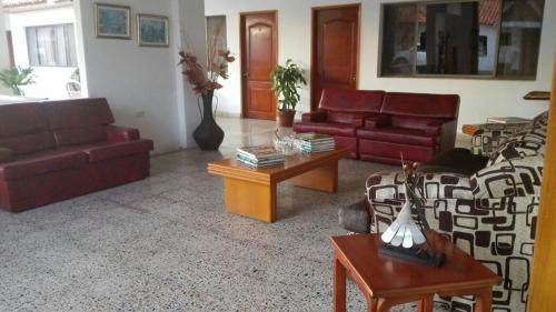 a living room with couches and tables in a room at Hotel Villa Ricaurte in Girardot