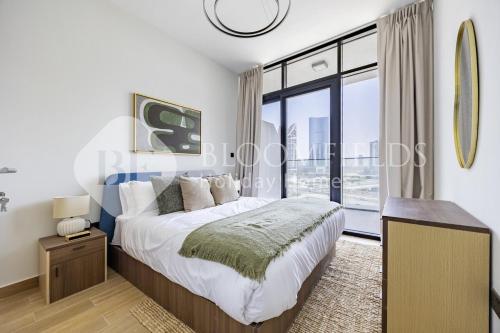 ein Schlafzimmer mit einem Bett und einem großen Fenster in der Unterkunft Bloomfields Serenity 1br Al Maryah Island in Abu Dhabi