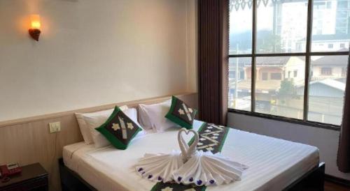 a bedroom with a bed with two pillows on it at Anoulack Khen Lao Hotel in Muang Phônsavan