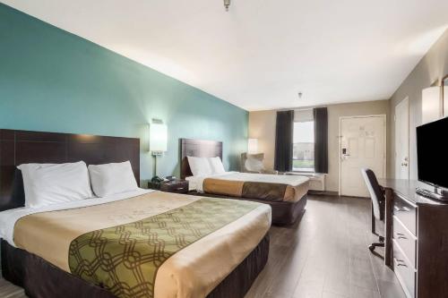 a hotel room with two beds and a flat screen tv at Econo Lodge Inn & Suites Brooks - Louisville South in Brooks