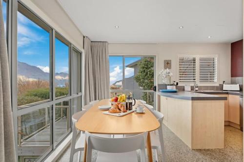 eine Küche und ein Wohnzimmer mit Tisch und Stühlen in der Unterkunft Vancouver Spa Views in Queenstown