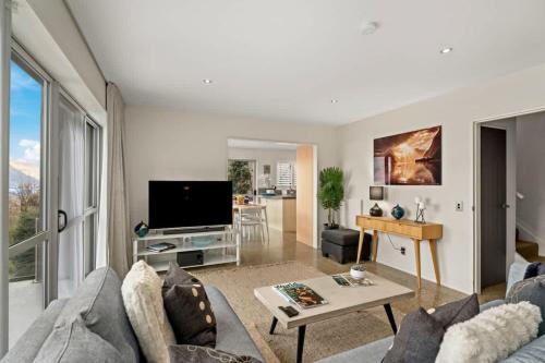 ein Wohnzimmer mit Sofa und Fernseher in der Unterkunft Vancouver Spa Views in Queenstown