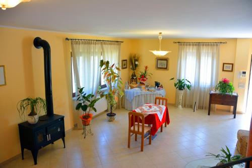 una sala de estar con mesa y una habitación con plantas en B&b La Nuova Stella, en Perano