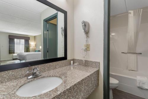 Un baño con lavabo, espejo e inodoro. en Clarion Pointe Kimball By Choice Hotels, en Kimball