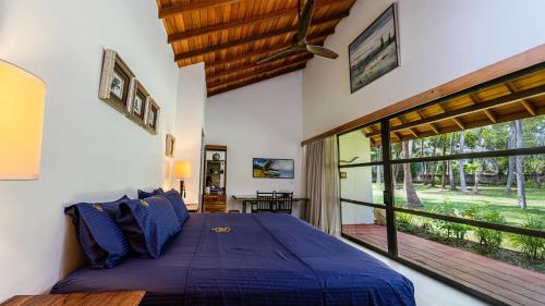 a bedroom with a bed and a large window at Villa Blue Lotus Katunayake in Katunayake