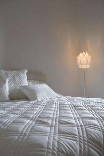 a bedroom with a white bed and a lamp at Mollisons in Kyneton