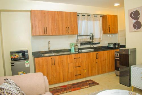 a kitchen with wooden cabinets and a sink at Carlton Stays in Nanyuki