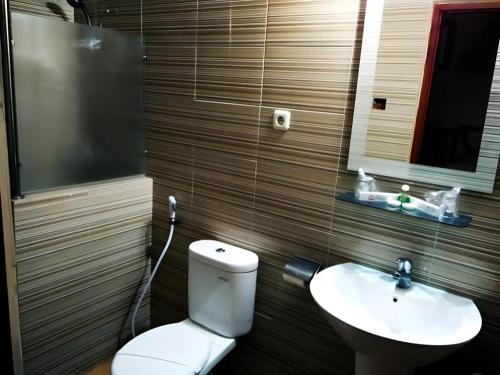 a bathroom with a toilet and a sink at Nikita Palace in Bukittinggi