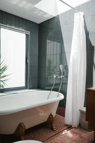 a bath tub in a bathroom with a window at Villa Cannary in Tegalharendong