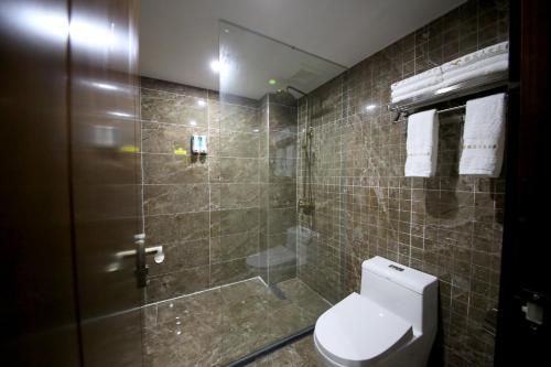 a bathroom with a toilet and a glass shower at Yazhu Creekfront Boutique Hotel in Zhangjiajie