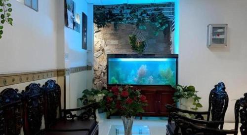 a living room with a fish tank in a wall at Quang Sang Hotel Can Tho in Can Tho
