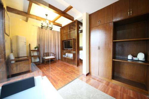 a living room with wooden cabinets and a television at Yazhu Creekfront Boutique Hotel in Zhangjiajie