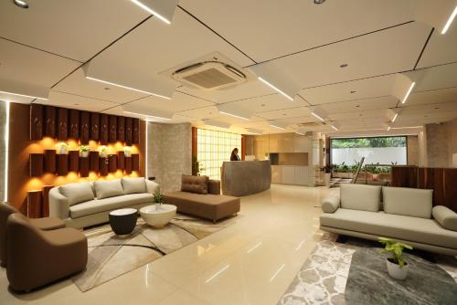 una grande hall con divani e sedie in un edificio di 23 Urban Suites, Hitech City a Hyderabad