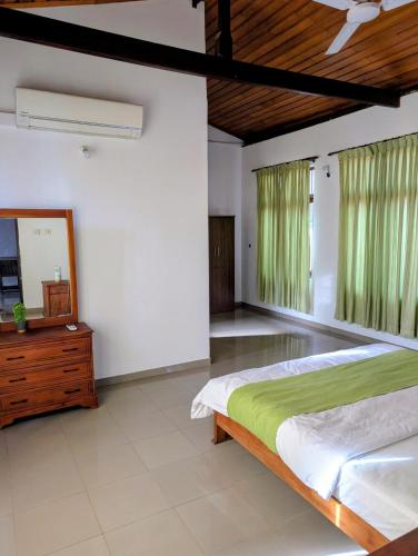 une chambre avec un lit, une commode et un miroir dans l'établissement Home in Colombo 06 - Minutes from Everywhere, à Kirillapone