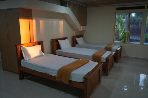 a room with three beds and a window at Sai Dham Room Stay-01 in Kalyānpur
