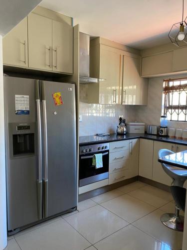 Cape TownUbuntu Guest House的厨房配有不锈钢冰箱和电器