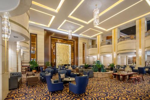 a lobby of a hotel with blue chairs and tables at Kempinski Hotel Guiyang in Guiyang