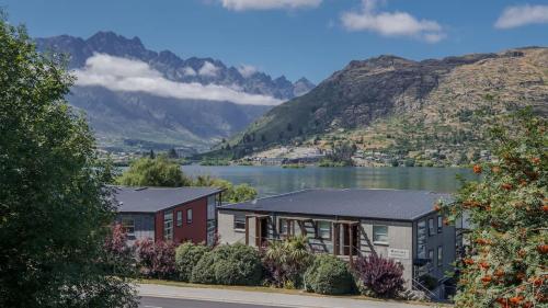 a house with a view of a lake and mountains at Marina Apartment 406 in Queenstown