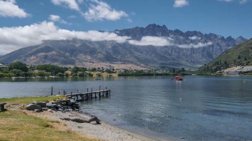 a lake with a dock and a boat in the water at Marina Apartment 406 in Queenstown