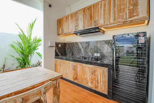 eine Küche mit Holzschränken und einer Arbeitsplatte in der Unterkunft The Lavana Hi Inn GWK in Uluwatu