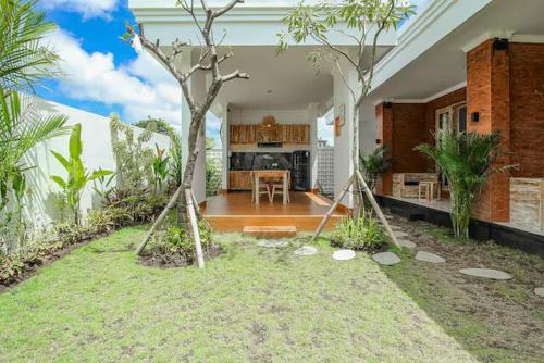 ein Haus mit Küche und einem Garten mit Bäumen in der Unterkunft The Lavana Hi Inn GWK in Uluwatu