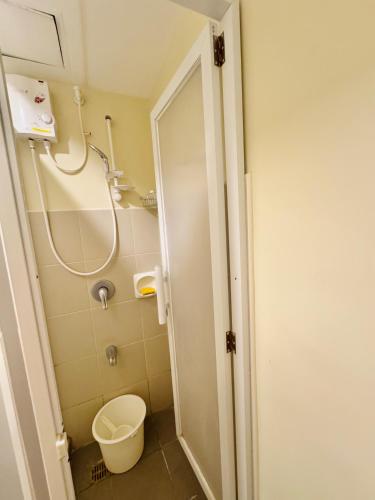 a small bathroom with a toilet and a shower at Condo Unit inside IT Park Lahug Cebu City in Cebu City