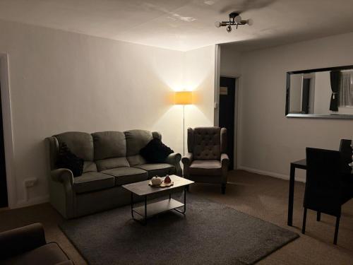 a living room with a couch and a table at Ty Cwmbwrla in Swansea