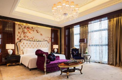 a bedroom with a bed and a couch and a chandelier at Wanda Realm Nanjing in Jiangning