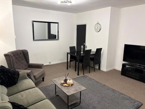 a living room with a couch and a table at Ty Cwmbwrla in Swansea