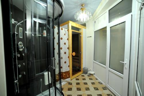 a bathroom with a shower and a glass door at Rich Hotel in Bishkek