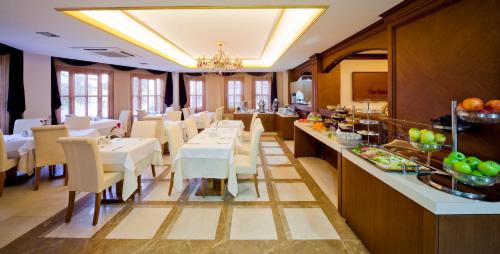 une salle à manger avec des tables et des chaises blanches dans l'établissement GLK PREMIER The Home Suites & Spa, à Istanbul
