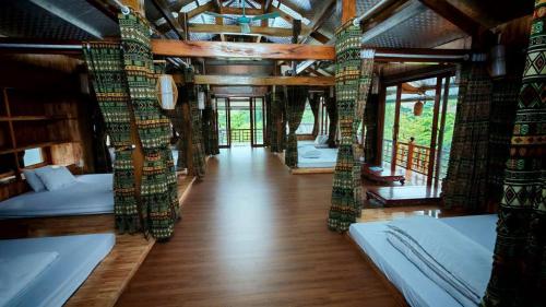 Zimmer mit mehreren Betten und Holzboden in der Unterkunft Homestay duy mạnh gần suối nước khoáng nóng trạm tấu in Cham Ta Lao