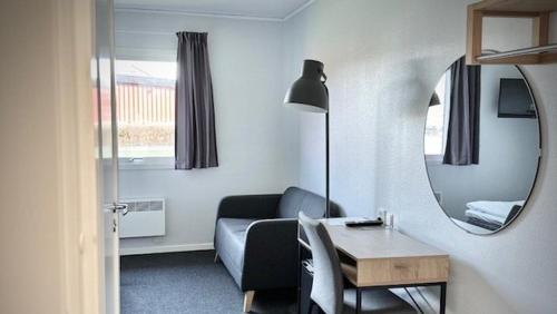 a living room with a couch and a table and a mirror at Hotel Surte in Surte