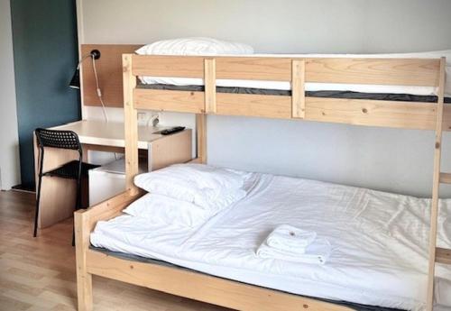 a bedroom with two bunk beds and a desk at Hotel Surte in Surte