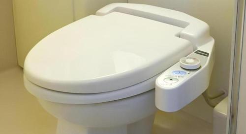ein Badezimmer mit einem weißen WC mit Fernbedienung in der Unterkunft Pearl Hotel Kawasaki in Kawasaki