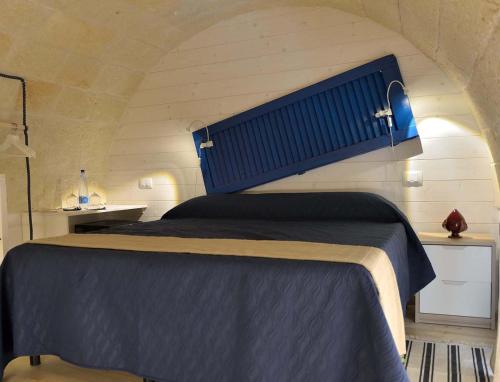 a bedroom with a bed with a blue head board at Palazzo Kapece in Monopoli