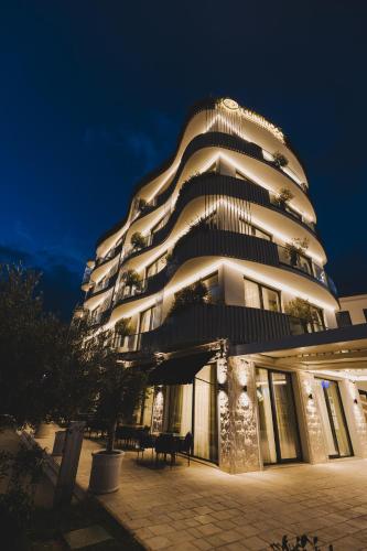 a large white building with lights on it at night at Luminoso Boutique Hotel in Budva
