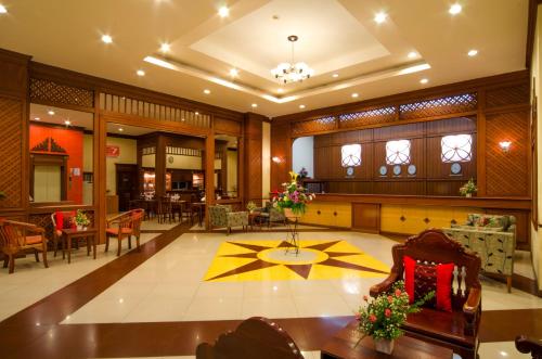 a lobby of a building with a table and chairs at Eastiny Seven Hotel in Pattaya