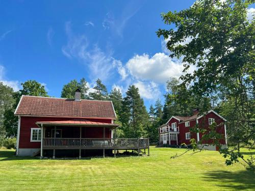 a red house with a deck and a house at Historic Dock House In The Heart Of Småland in Hult