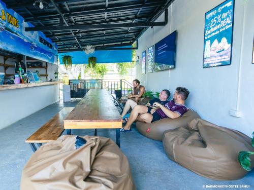 a group of people sitting on a couch in a bar at Bad Monkey Samui Hostel in Chaweng