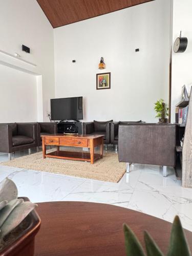 ein Wohnzimmer mit Sofa und Fernseher in der Unterkunft The Coffee Retreat in Mudigere