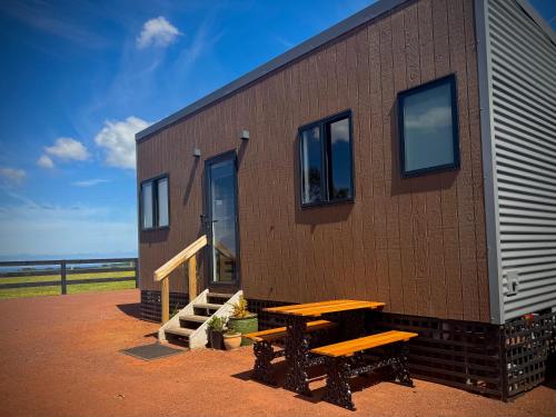 Un edificio con una mesa de picnic delante. en The Tiny Apostle - Great Ocean Road, en Princetown