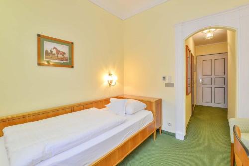 a bedroom with a large white bed in a room at Romantik Hotel zur Post in Fürstenfeldbruck