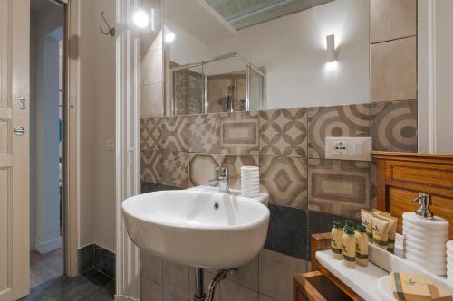 a bathroom with a white sink and a mirror at Belduomo Catania Rooms & Flat in Catania