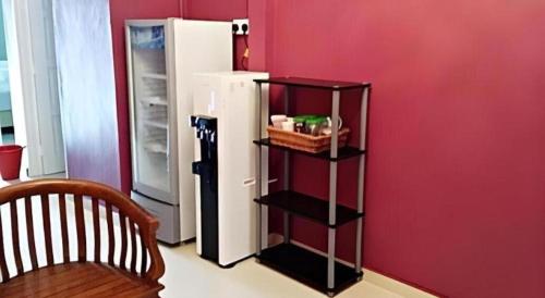 a black shelf next to a refrigerator in a room at HOTEL BAJET MUGHOH SENGOTI in Kampong Gong Kempas