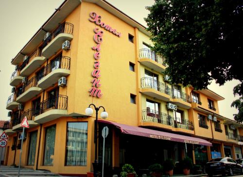Hotel Elegant في كارنوبات: مبنى أصفر اللون عليه لافتة فندق