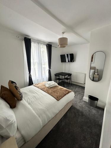 a bedroom with a bed and a table and a mirror at The Luma Suite in Albrighton
